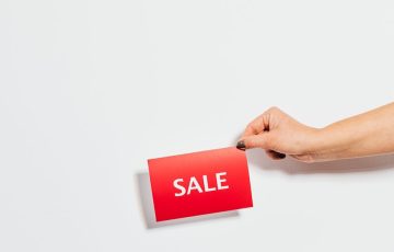 person holding sale card