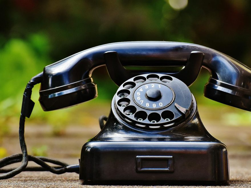 selective focus photography of black rotary phone