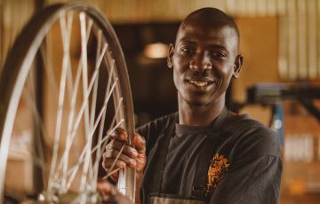 smiling man holding wheel in workshop