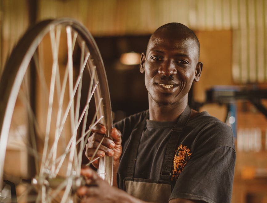 smiling man holding wheel in workshop