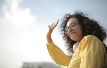 woman in yellow top waving