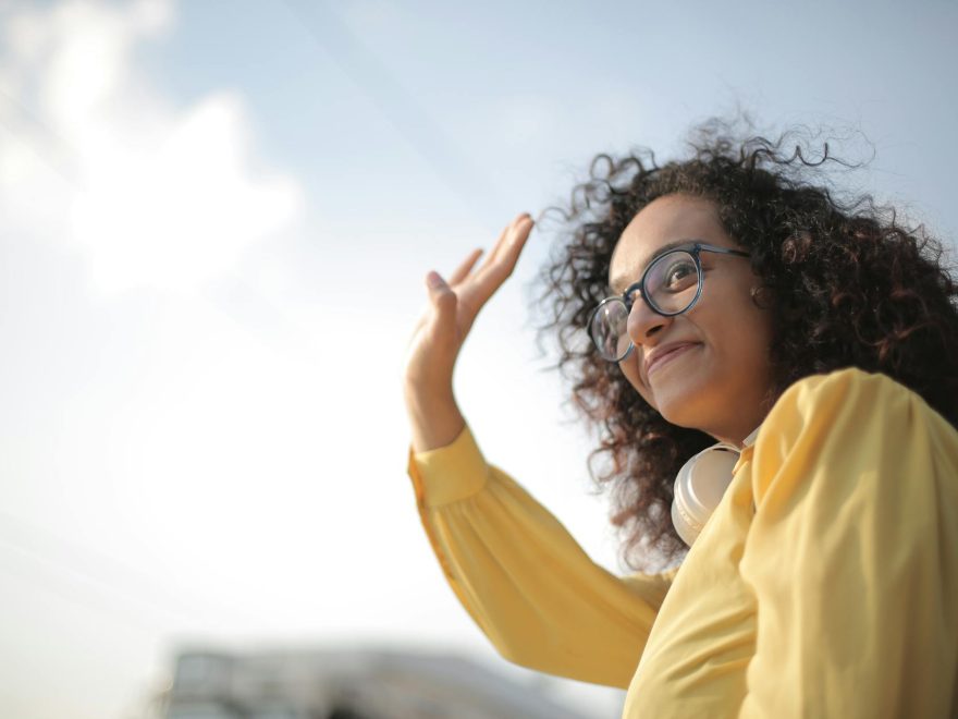 woman in yellow top waving